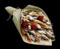 Bouquet consisting of dried fish, chips, pistachios and snacks on a black background as a gift to her husband