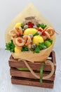 Bouquet consisting of honey, a bunch of bagels, mint leaves, lemons, lime, ginger and red currant in a wooden decorative box