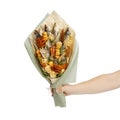 Bouquet consisting of salted stockfish of different breeds, slices of dried squid and other fish is in male hand on the white back Royalty Free Stock Photo