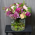 Bouquet with cream roses and purple flowers in a glass vase Royalty Free Stock Photo