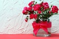 Bouquet of crimson roses in a glass vase with a bow. Royalty Free Stock Photo