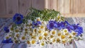 A bouquet of daisies and cornflowers on a wooden background. A beautiful bouquet of summer flowers Royalty Free Stock Photo