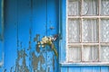 Bouquet of daisies stuck in the handle of the closed door of the old wooden house