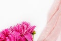 Bouquet of dark pink peony flowers close-up and pink fabric on white background with copy space. Royalty Free Stock Photo