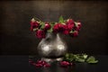 Bouquet of dead red roses in pewter vase, grunge background Royalty Free Stock Photo