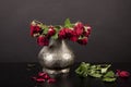 Bouquet of dead red roses, silver vase, black background Royalty Free Stock Photo
