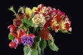 A bouquet of different colored flowers inside a glass vase isolated on black Royalty Free Stock Photo