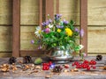 A bouquet of different summer wildflowers in a metal vase on the porch of a country house Royalty Free Stock Photo