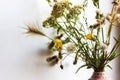 Bouquet of different wildflowers in small vase Flowers in cozy home interior.