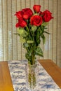 A Bouquet of a dozen red roses in a glass insert