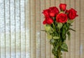 A Bouquet of a dozen red roses in a glass insert