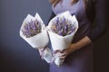 Bouquet of dried flowers in the hands of a florist girl lavender cereal on a gray background