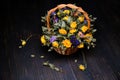 Bouquet of dried flowers on a wooden background. Dry yellow roses in a wicker basket. Beautiful faded flowers on the boards of Royalty Free Stock Photo