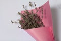 A bouquet of dried flowers, wrapped in colored paper. On a white background