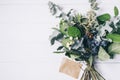 Bouquet of dried wild flowers on white table background with natural wood vintage planks wooden texture top view horizontal Royalty Free Stock Photo