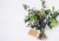 Bouquet of dried wild flowers on white table background with natural wood vintage planks wooden texture top view horizontal Royalty Free Stock Photo