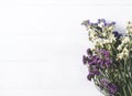 Bouquet of dried wild flowers on white table background with natural wood vintage planks wooden texture top view horizontal Royalty Free Stock Photo