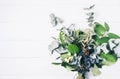 Bouquet of dried wild flowers on white table background with natural wood vintage planks wooden texture top view horizontal