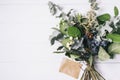 Bouquet of dried wild flowers on white table background with natural wood vintage planks wooden texture top view horizontal, empty Royalty Free Stock Photo