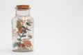 Bouquet of dry flowers and potpourri in a glass jar on a white table