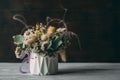 Bouquet of dry flowers in white vase on wooden table on black background. Royalty Free Stock Photo