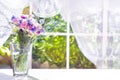 Bouquet of field flowers in glass vase near the window Royalty Free Stock Photo