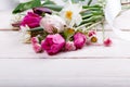 Bouquet first spring flowers, pink, purple tulips, daffodils and daisies on white wooden background. Royalty Free Stock Photo