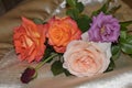 Bouquet of five roses of red, orange, lilac and pink on a nappy surface of Golden color Royalty Free Stock Photo