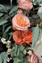 Bouquet of flowers in black mate paper. Anthurium, rose and pink carnation with leaves. Closeup view.