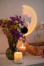 Bouquet of flowers, burning candles and projector lamp with image of moon create romantic mood. Royalty Free Stock Photo