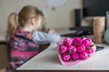 A bouquet of flowers from colored corrugated paper in the shape of tulips with a candy inside on the table. In the background, a Royalty Free Stock Photo