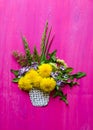 bouquet of flowers dandelions of grass and leaves with a painted paper basket