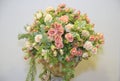 A bouquet of flowers on display against a light grey plain backdrop