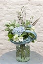 A bouquet of flowers is in a glass vase on the table . blue flowers. Bouquet with hydrangea close-up. Royalty Free Stock Photo