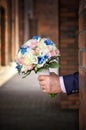 Bouquet of flowers in the hand of the groom