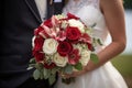 Bouquet of flowers in the hands of the bride with the groom