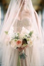 Bouquet of flowers in the hands of a bride in a veil. Close-up Royalty Free Stock Photo