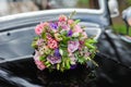 Bouquet of flowers on hood retro wedding car Royalty Free Stock Photo