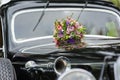 Bouquet of flowers on hood retro wedding car Royalty Free Stock Photo