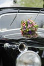 Bouquet of flowers on hood retro wedding car Royalty Free Stock Photo