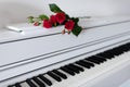 A bouquet of flowers lies on the piano with the keys open.