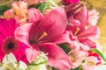 A bouquet of flowers from a lily, gerbera, white roses and alstroemeria on a white wooden table. A holiday, a gift. Royalty Free Stock Photo