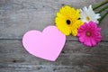 Bouquet of flowers with pink paper heart on wood