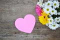 Bouquet of flowers with pink paper heart on wood Royalty Free Stock Photo