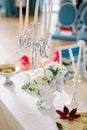 Bouquet of flowers stands on the table next to flat bread on a plate and candles in front of the mirror. Persian Royalty Free Stock Photo