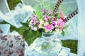 Bouquet of flowers in the style of boho in a glass vase in nature