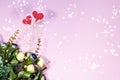 Bouquet of flowers and two red hearts on pink festive light magic background. Concept Valentine`s day, mother`s holiday, wedding Royalty Free Stock Photo