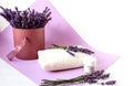 Bouquet of fragrant lavender flowers in a vase with a white bath towel and body cream, close-up, lilac background, place for the Royalty Free Stock Photo