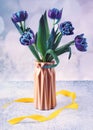 Blue tulips in a vase. Still life with spring flowers on a light blue background. Royalty Free Stock Photo