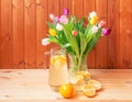 Bouquet of fresh colorful tulips and fresh homemade lemonade on wooden table Royalty Free Stock Photo